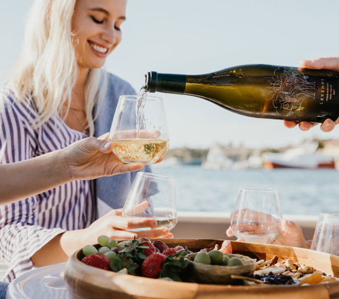 people drinking wine by the water